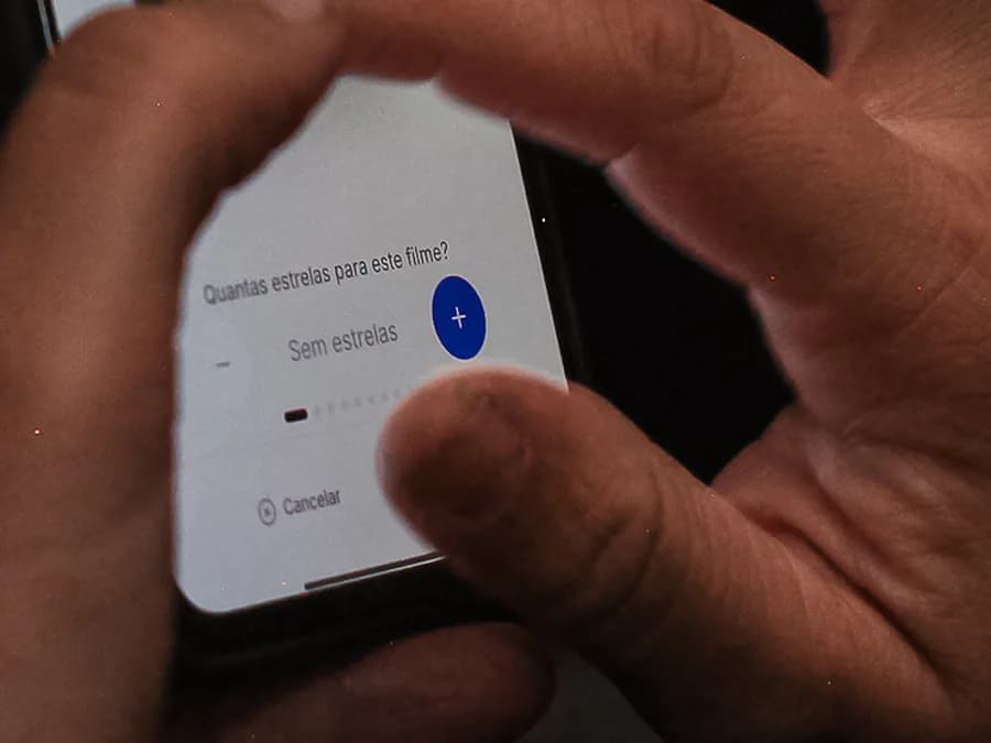Na Noite de Estreia, um dedo toca a tela do celular que pergunta quantas estrelas o filme merece.