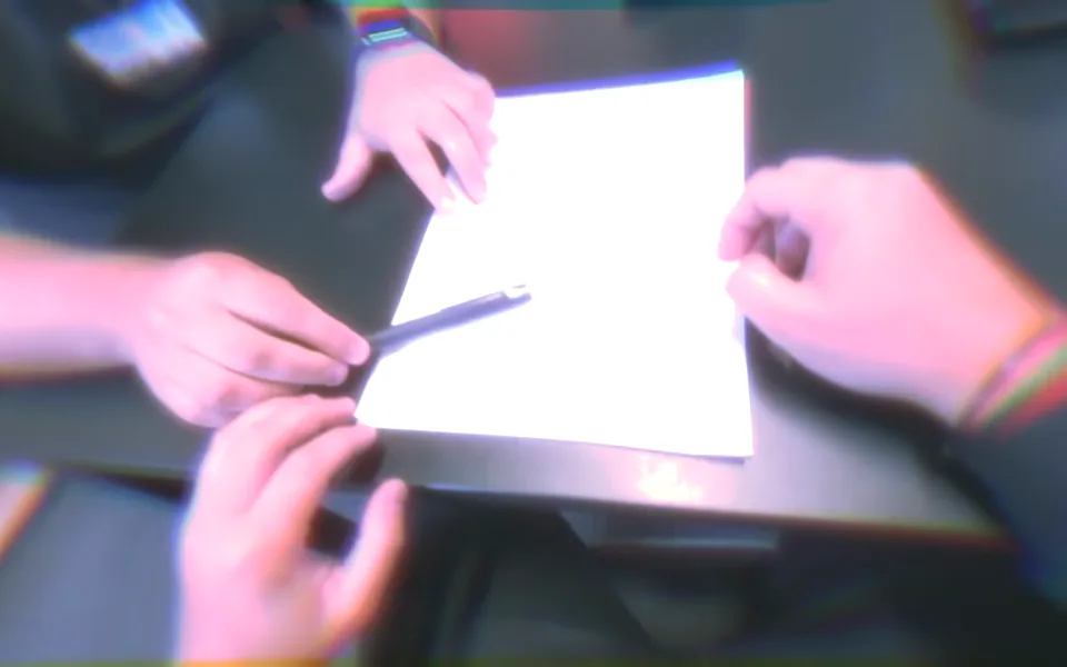 Quadro do vídeo interativo em primeira pessoa: mãos assinam um contrato sobre a mesa.