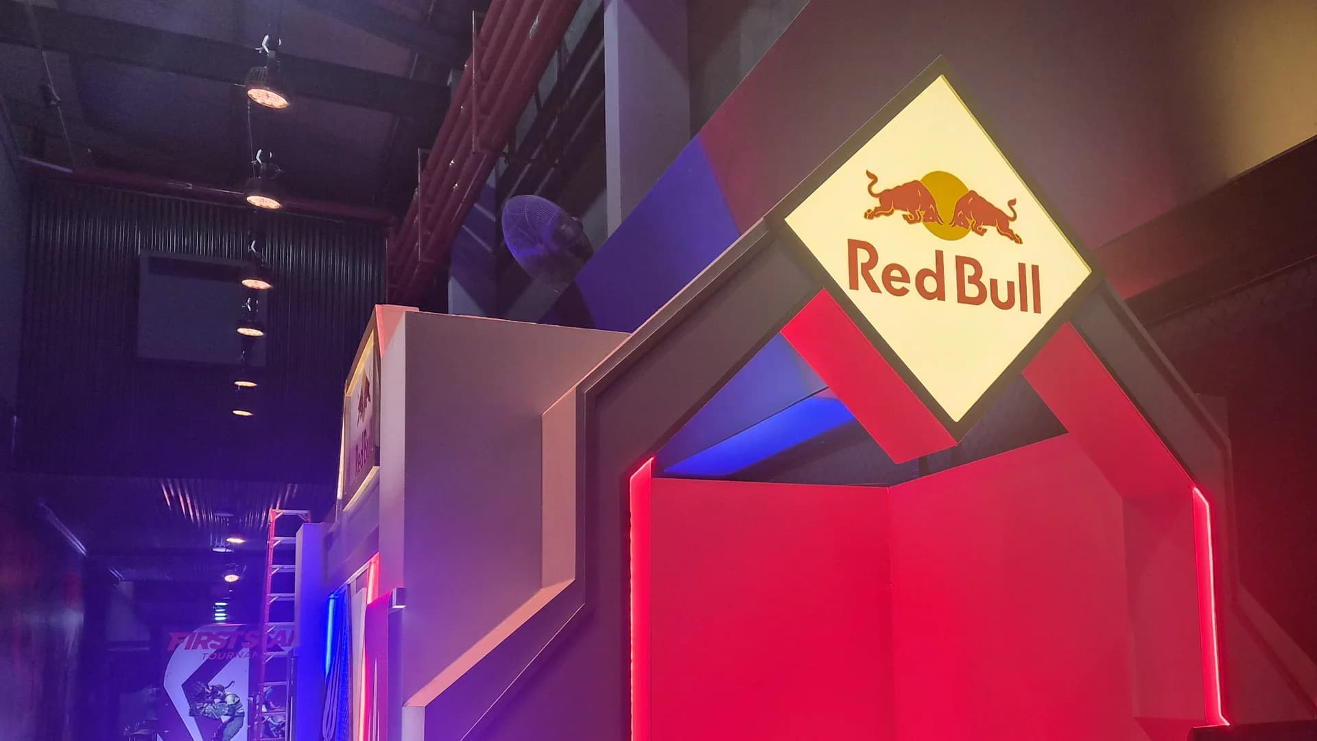 O portal do estande da Red Bull no First Stand, com o logo no alto e a entrada acesa em vermelho, na véspera do torneio.